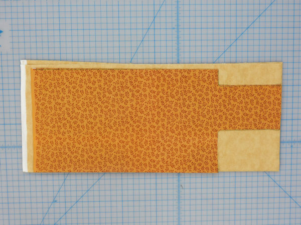 Laying the cut piece onto the fabric that is not cut.